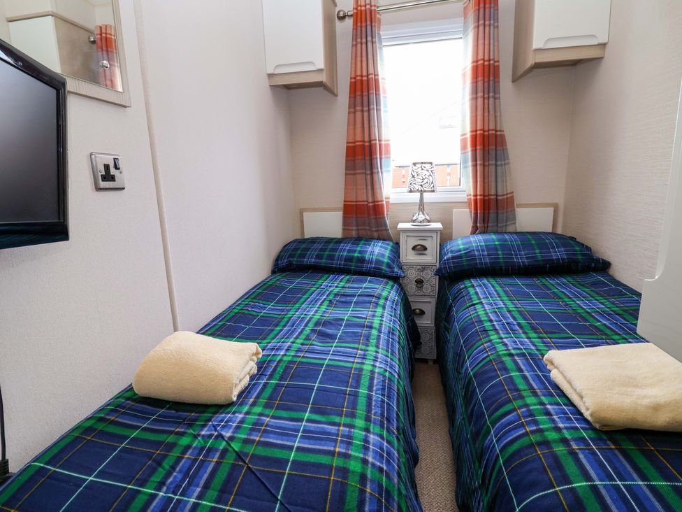 A bedroom with two beds and a lamp at 15 Cherry Tree walk in Rhyl