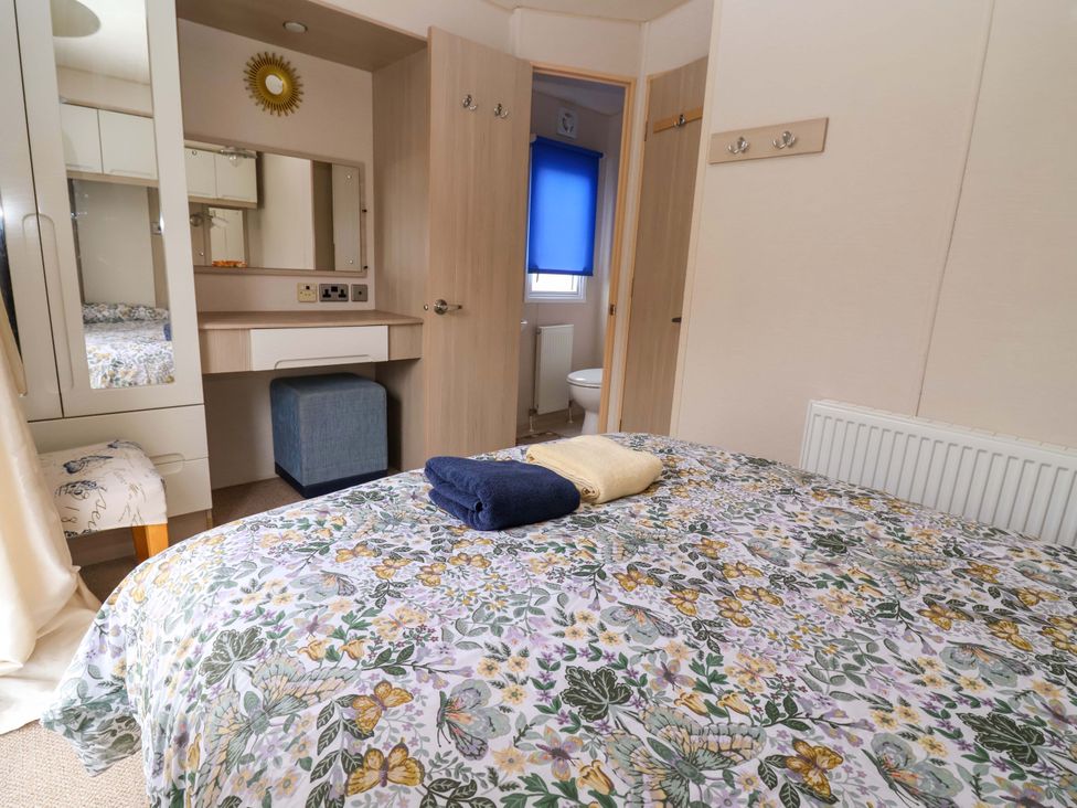 A bedroom with a bed and dressing table at 15 Cherry Tree Walk in Rhyl