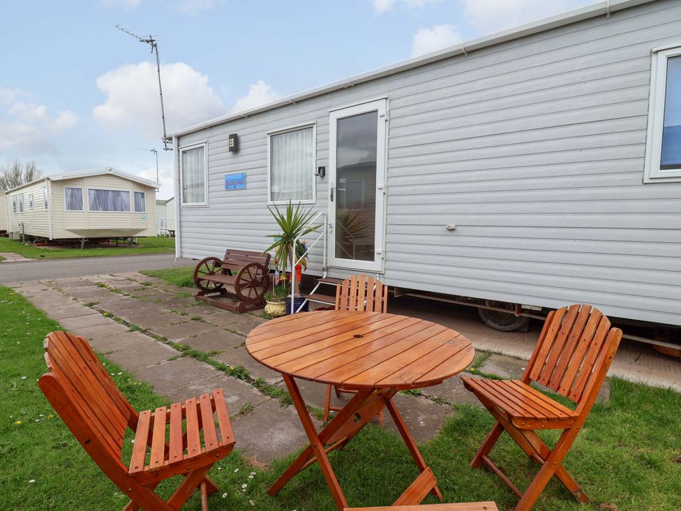 Outdoor area with a table and chairs in front of a caravan at 15 Cherry Tree walk Rhyl