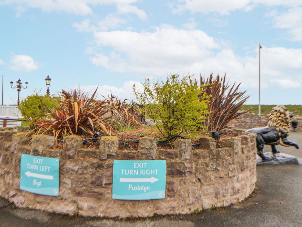 A decorative stonewall with plants and signs in Prestatyn