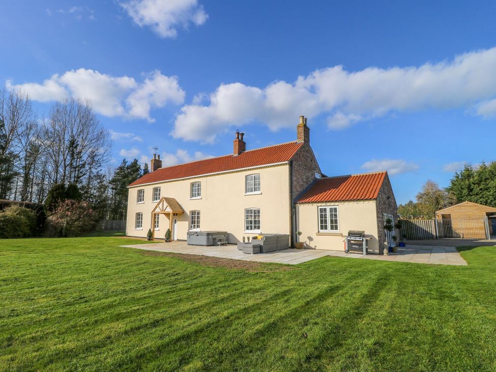 A house with a lawn and patio at Tuft House in Hovingham
