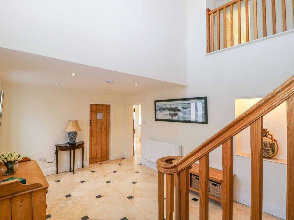 A hallway with a staircase and a table at Tuft House in Hovingham