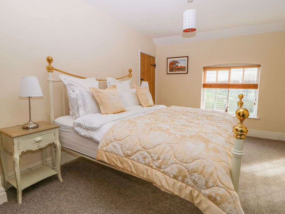 A bedroom with a bed and bedside table at Tuft House in Hovingham