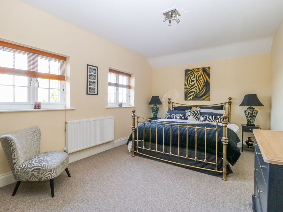 A bedroom with a bed and chair at Tuft House in Hovingham