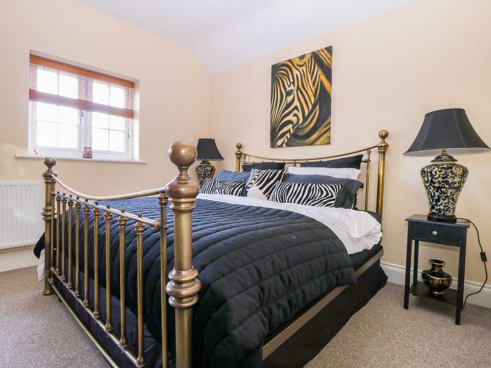 A bedroom with a bed and decorative items at Tuft House in Hovingham