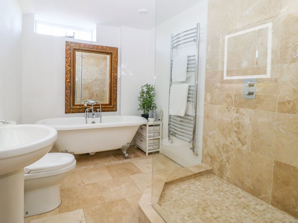 A bathroom featuring a bathtub, shower, and sink at Tuft House in Hovingham