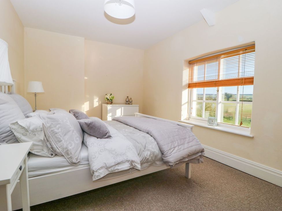 A bedroom with a bed, lamp, and window at Tuft House in Hovingham