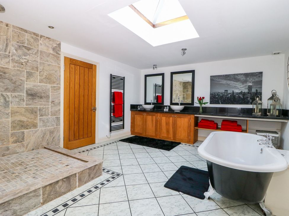A bathroom with a bathtub and sinks at Tuft House in Hovingham
