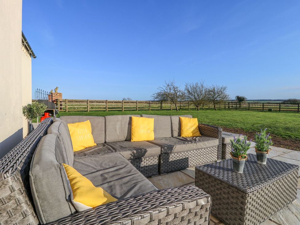 An outdoor seating area with a sofa and coffee table at Tuft House in Hovingham