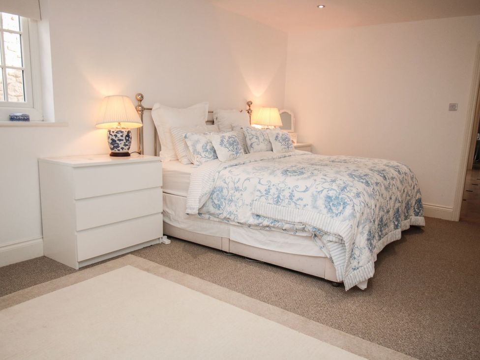 A bedroom with a bed and bedside table at Tuft House in Hovingham
