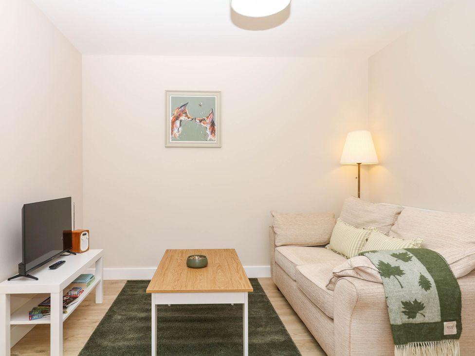 A living room with a sofa and coffee table at Little Folley in Whitestone near Tedburn St Mary