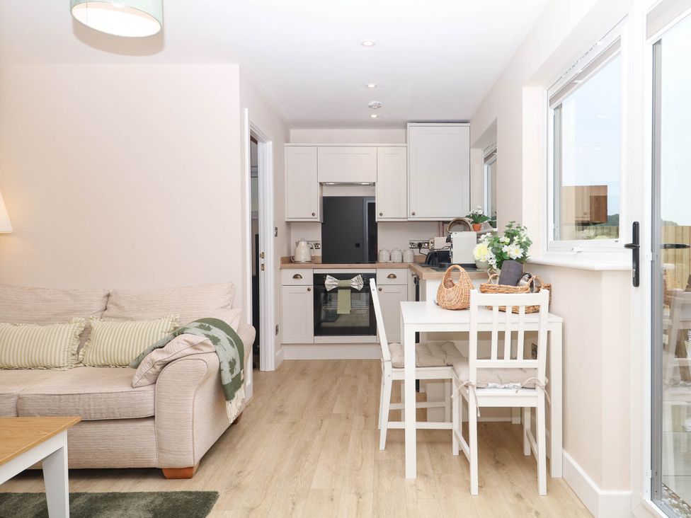 A kitchen area with seating and appliances at Little Folley in Whitestone near Tedburn St Mary