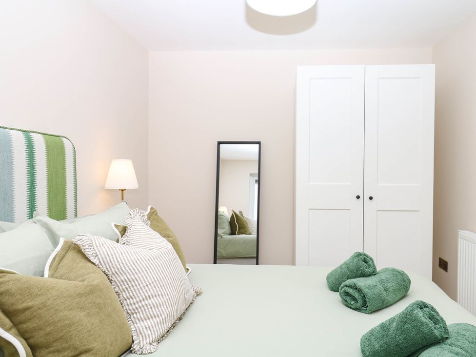A bedroom with a bed and wardrobe at Little Folley in Whitestone near Tedburn St Mary
