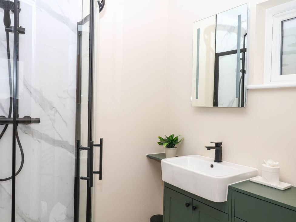 A bathroom with a shower and sink at Little Folley in Whitestone near Tedburn St Mary