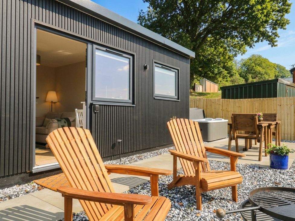 An outdoor area with chairs and a table at Little Folley in Whitestone near Tedburn St Mary