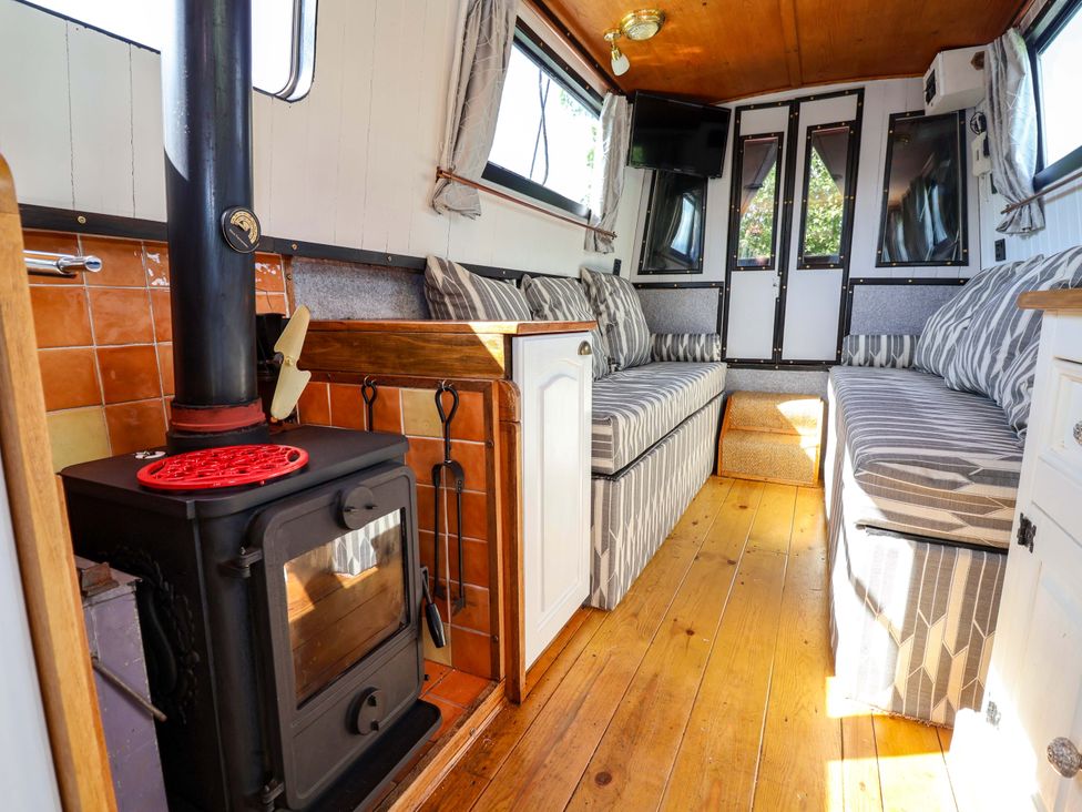 A living room with a wood stove and sofa at Escape II in Oakwood Marina
