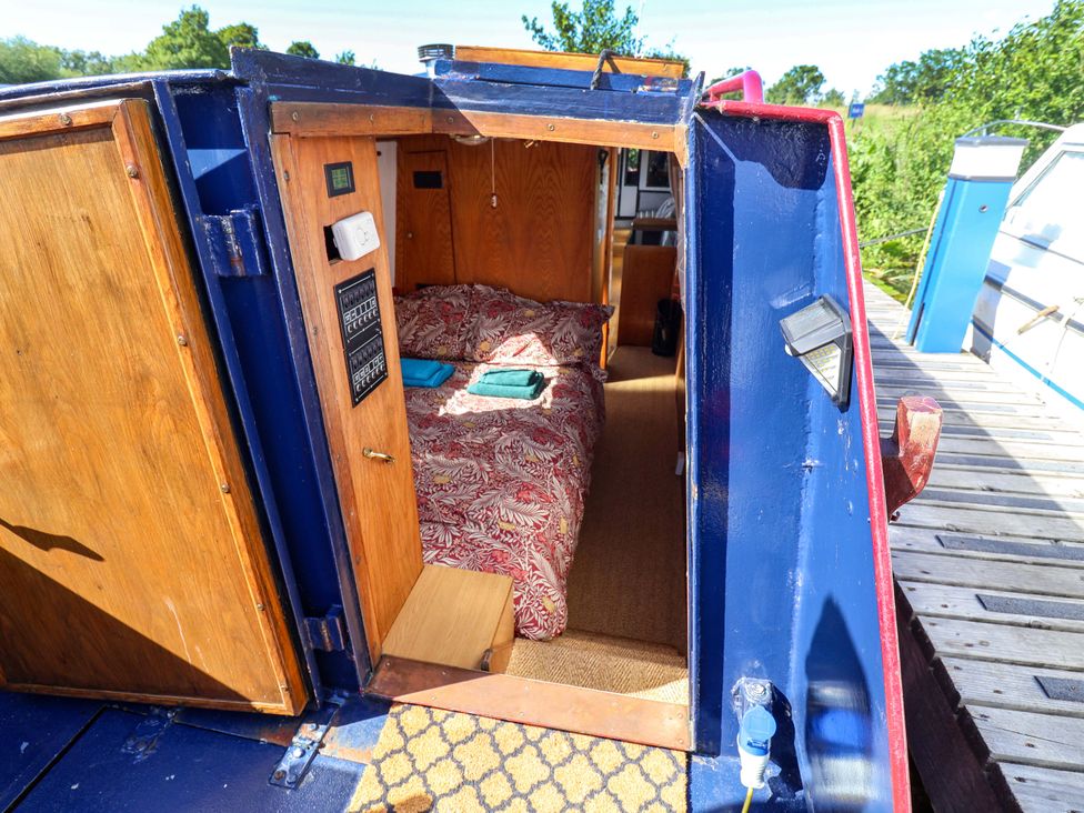 A bedroom with a bed and wooden door at Escape II in Oakwood Marina