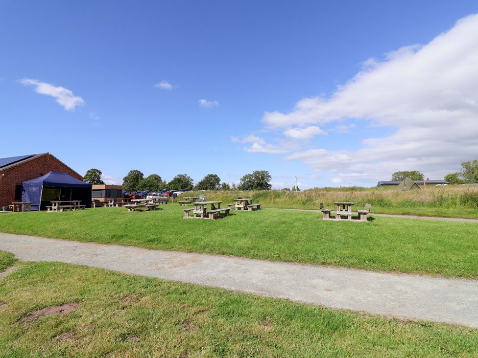 An outdoor area with picnic tables and a building at Escape II Oakwood Marina