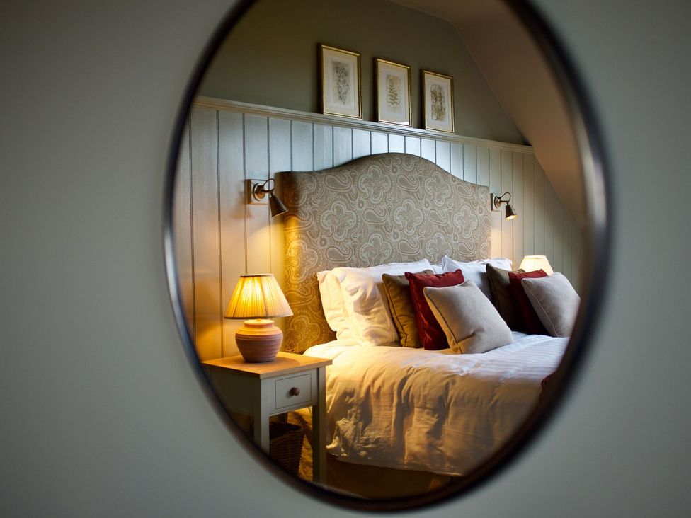 A bedroom with a bed and bedside lamp at The Chimney in Bamburgh