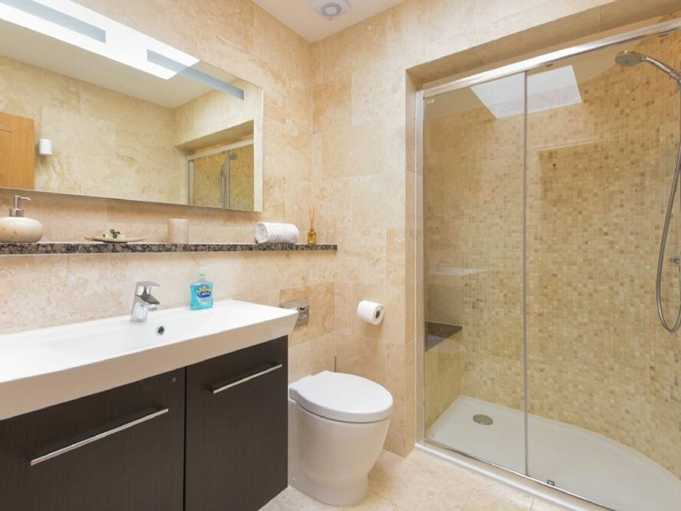A bathroom with a shower, sink, and toilet at The Chimney in Bamburgh