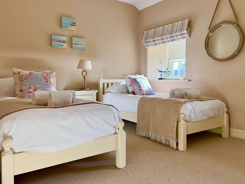 A bedroom with two beds and a nightstand at The Chimney in Bamburgh