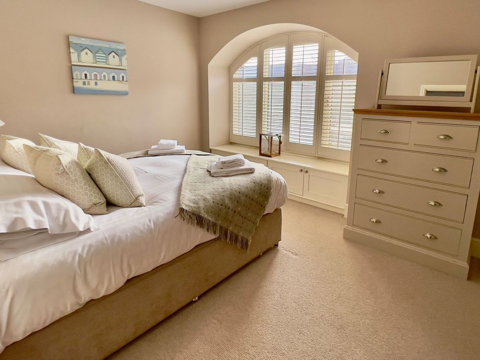 A bedroom with a bed and dresser at The Chimney in Bamburgh