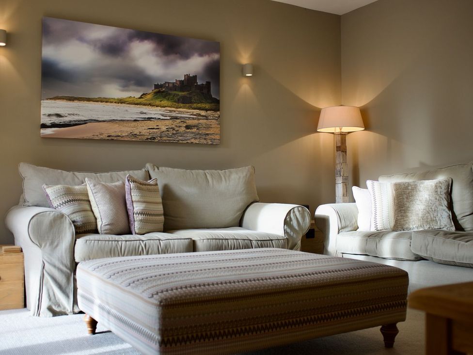 A living room with a sofa and ottoman at The Chimney in Bamburgh