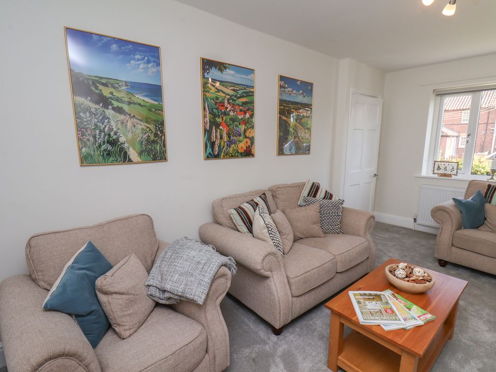 A living room with sofas and wall art at Helmsley Cottage in Helmsley