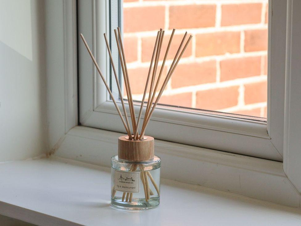 A diffuser with reed sticks on a windowsill at Helmsley Cottage Helmsley