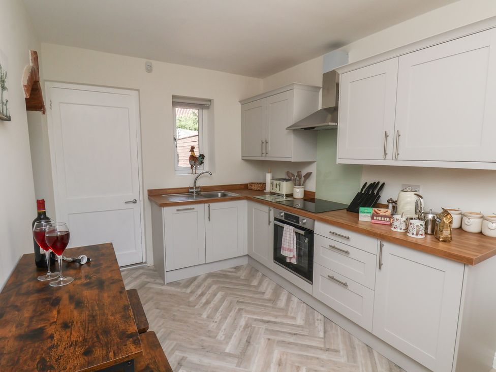 A kitchen with cabinets and a sink at Helmsley Cottage in Helmsley