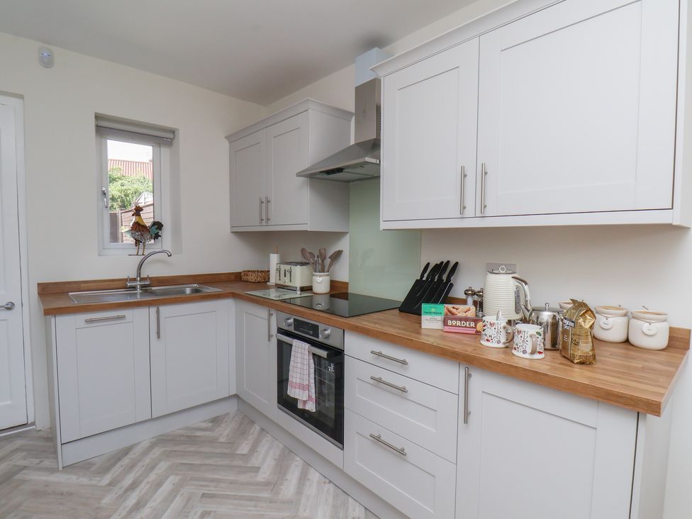 A kitchen with cabinets and appliances at Helmsley Cottage Helmsley