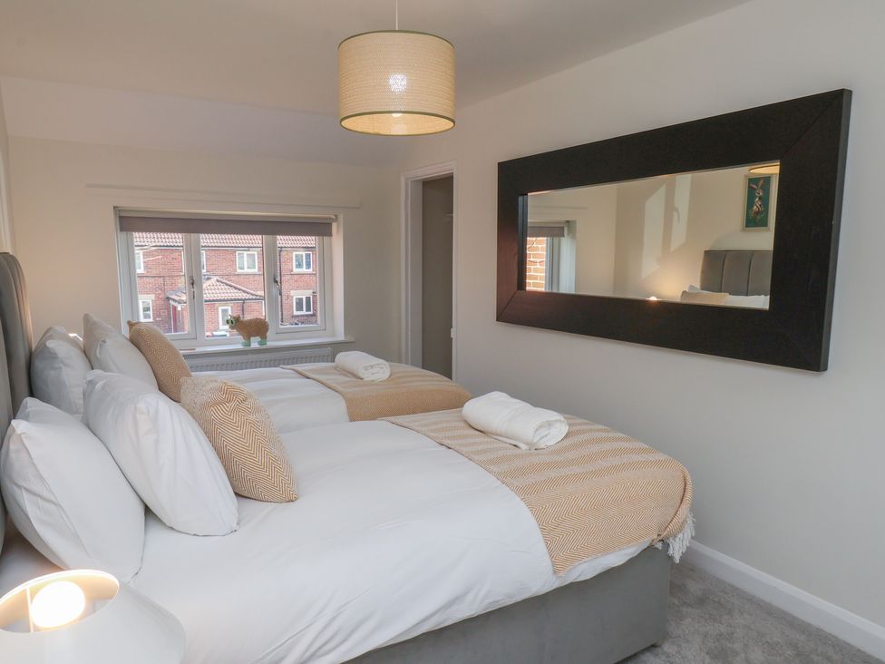 A bedroom with two beds and a window at Helmsley Cottage in Helmsley