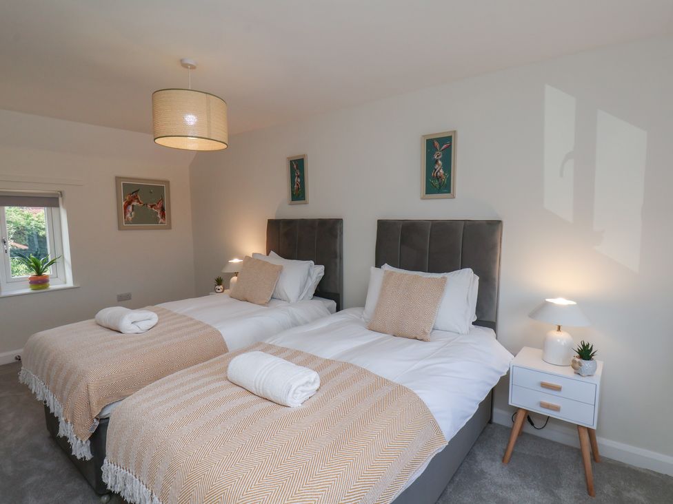 A bedroom with two single beds and a lamp at Helmsley Cottage in Helmsley