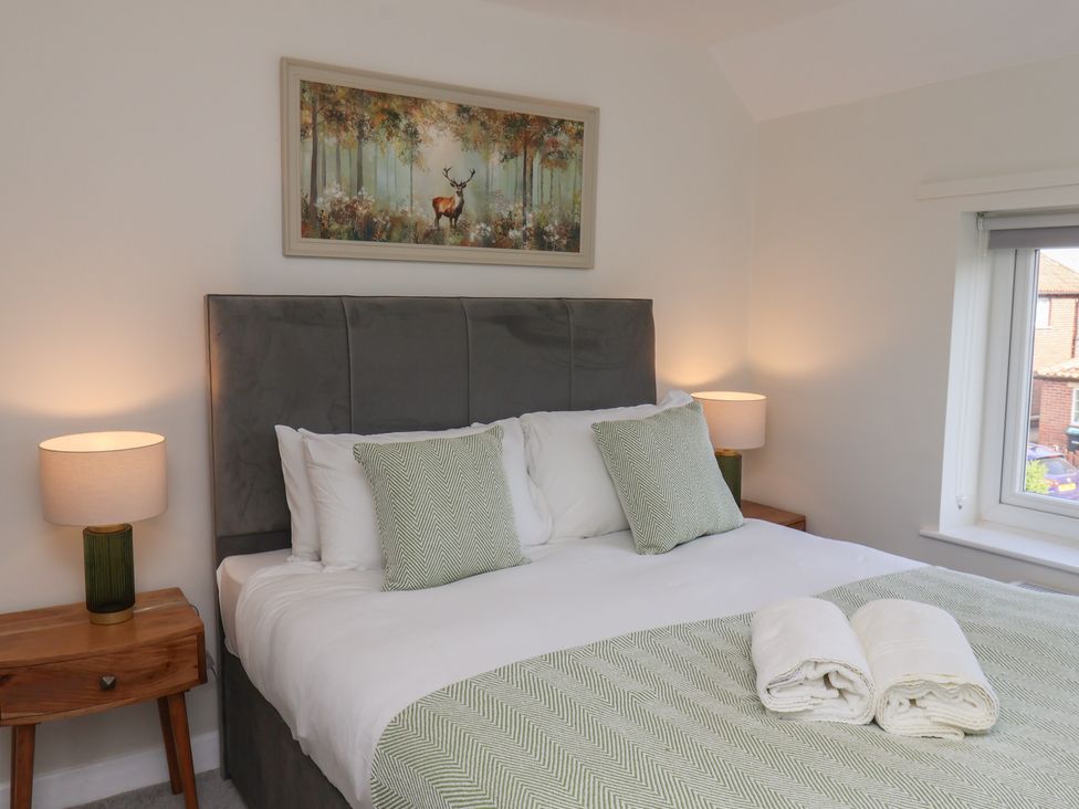 A bedroom with a bed and lamps at Helmsley Cottage in Helmsley