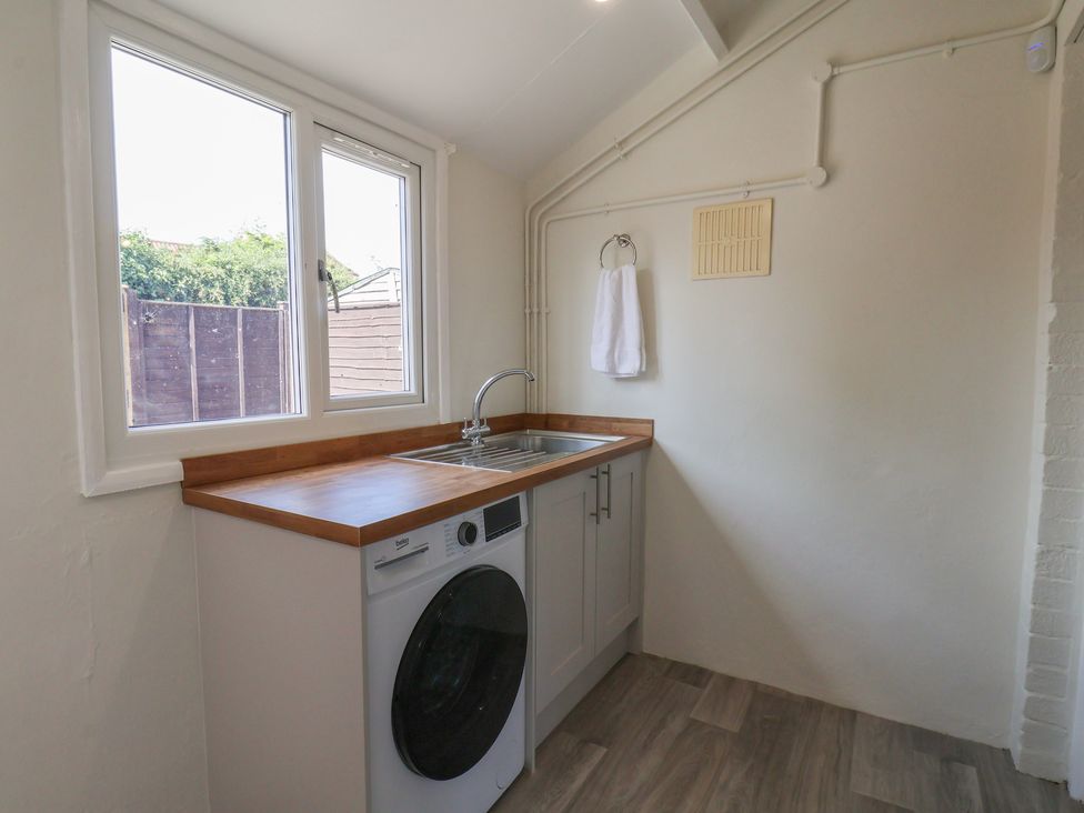A laundry room with a washing machine and sink at Helmsley Cottage in Helmsley
