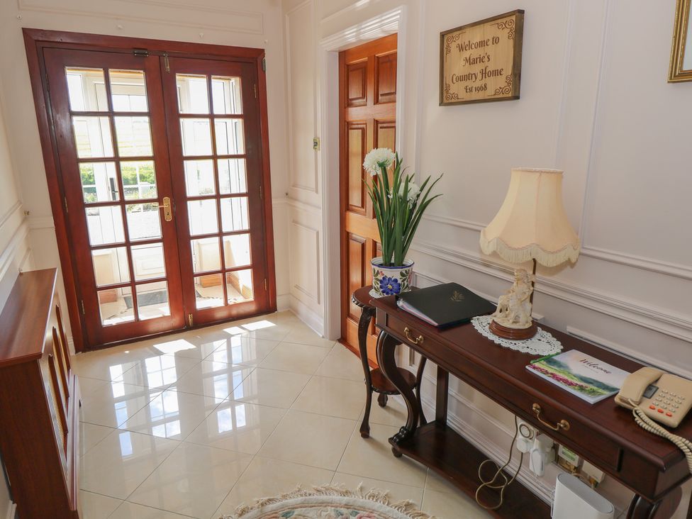 A hallway with double doors and a table with a lamp at Marie's Country Home in Ardee, County Louth