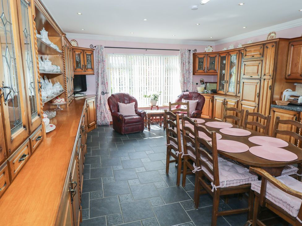 A kitchen with wooden cabinets and a dining table at Marie's Country Home, Ardee, County Louth