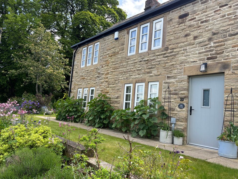 A house with a garden and trees at Holly Cottage in Totley