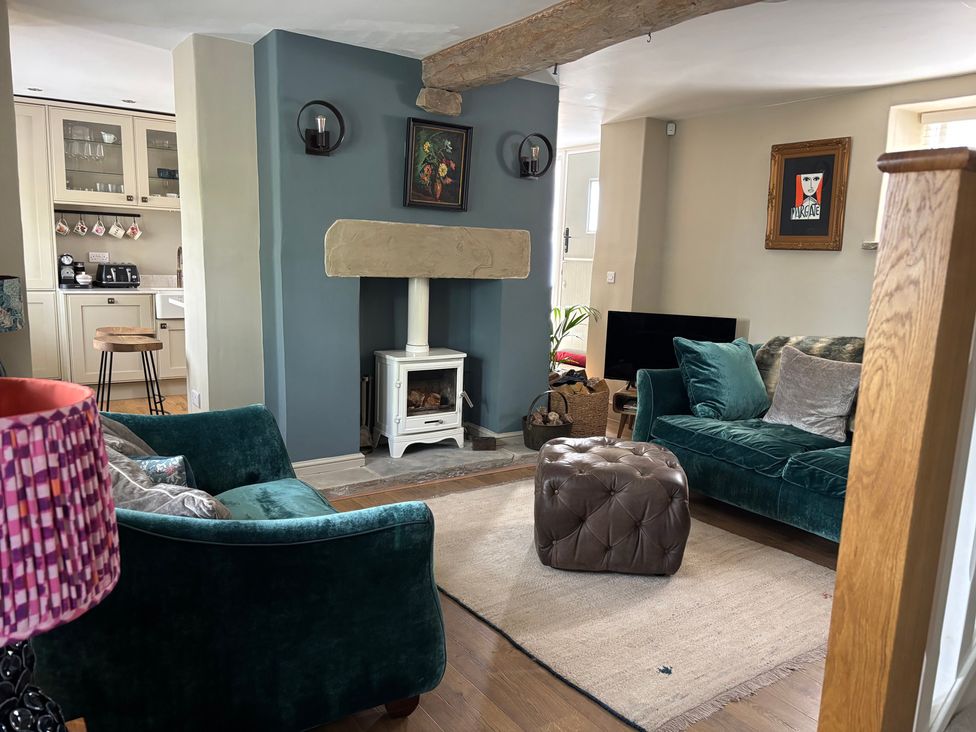 A living room with a sofa and fireplace at Holly Cottage in Totley