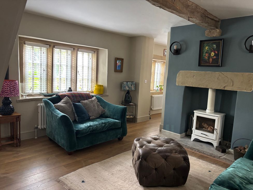 A living room with a sofa and a footstool at Holly Cottage in Totley