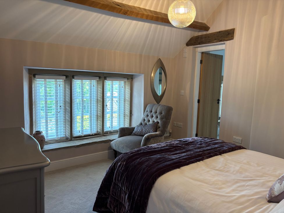 A bedroom with a window, bed and chair at Holly Cottage in Totley