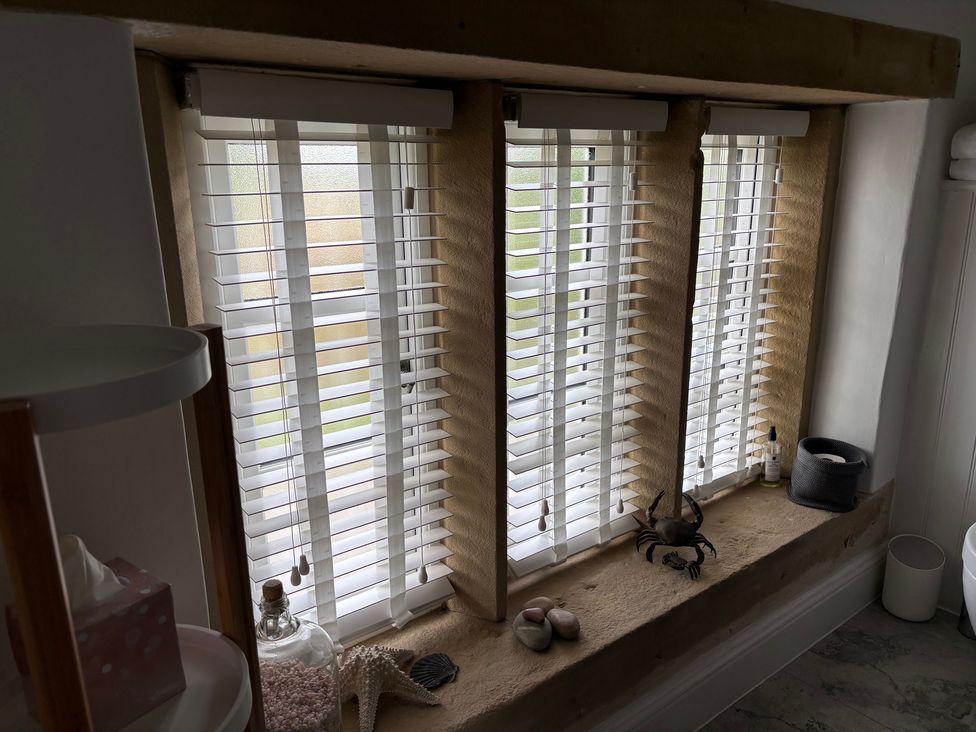 A bathroom window with blinds and decorative objects at Holly Cottage in Totley