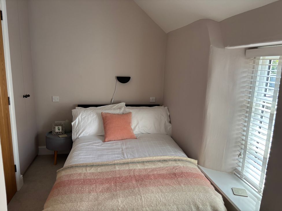A bedroom with a bed and bedside table at Holly Cottage in Totley