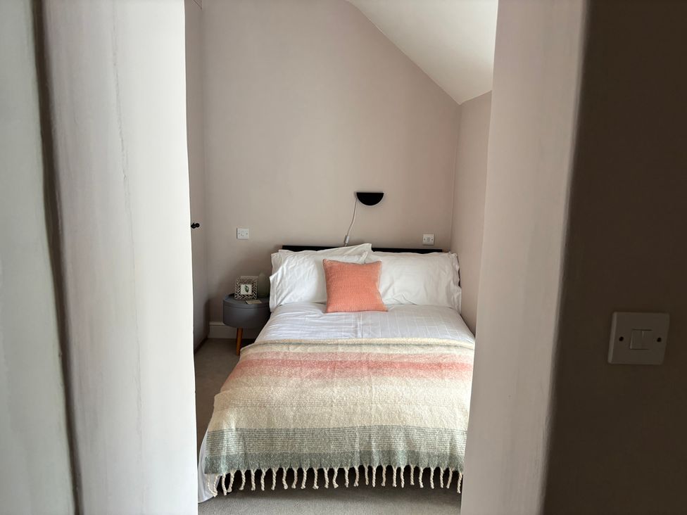 A bedroom with a bed and nightstand at Holly Cottage in Totley