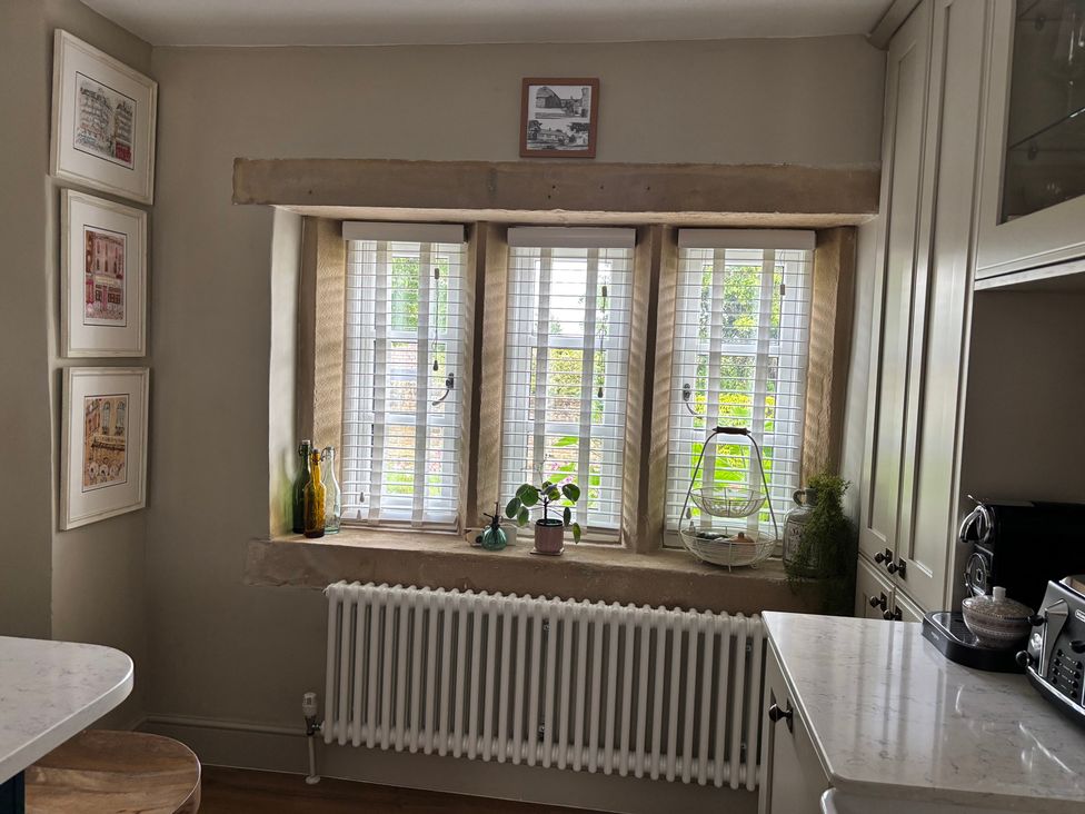 A kitchen with windows and a radiator at Holly Cottage in Totley
