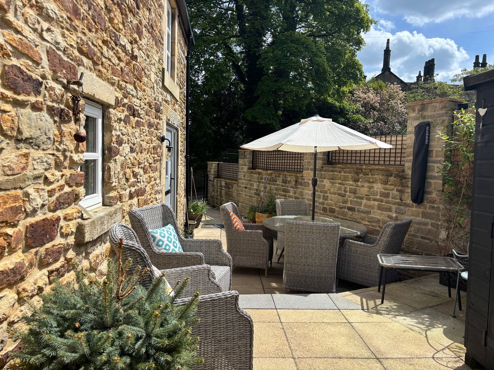 An outdoor patio with a table and chairs at Holly Cottage in Totley