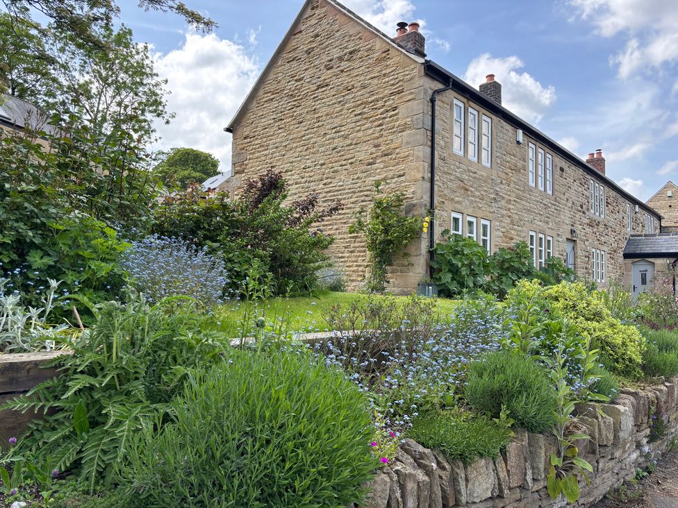 A house with a garden and flowers at Holly Cottage in Totley