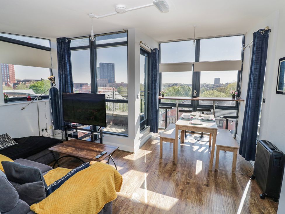 A living room with a sofa and a dining area at Apartment 10 in Birmingham