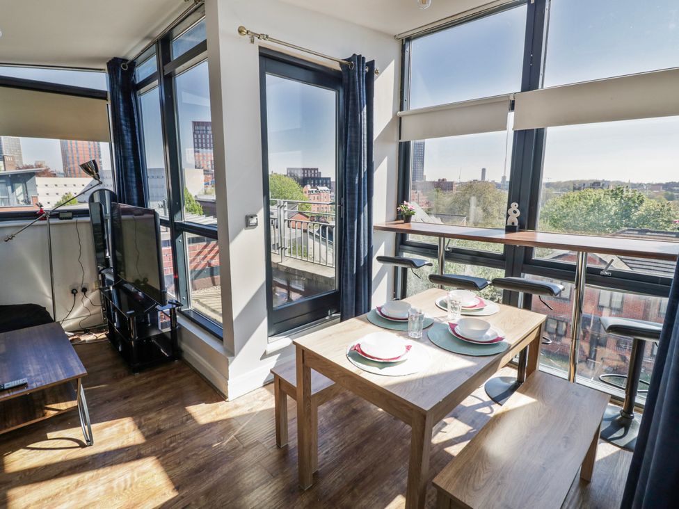 A dining room with a table and bar stools at Apartment 10 in Birmingham