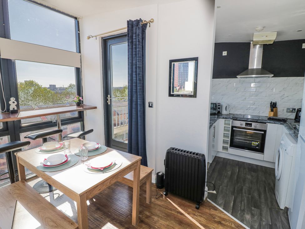 A dining area with a table and chairs adjacent to a kitchen at Apartment 10 in Birmingham